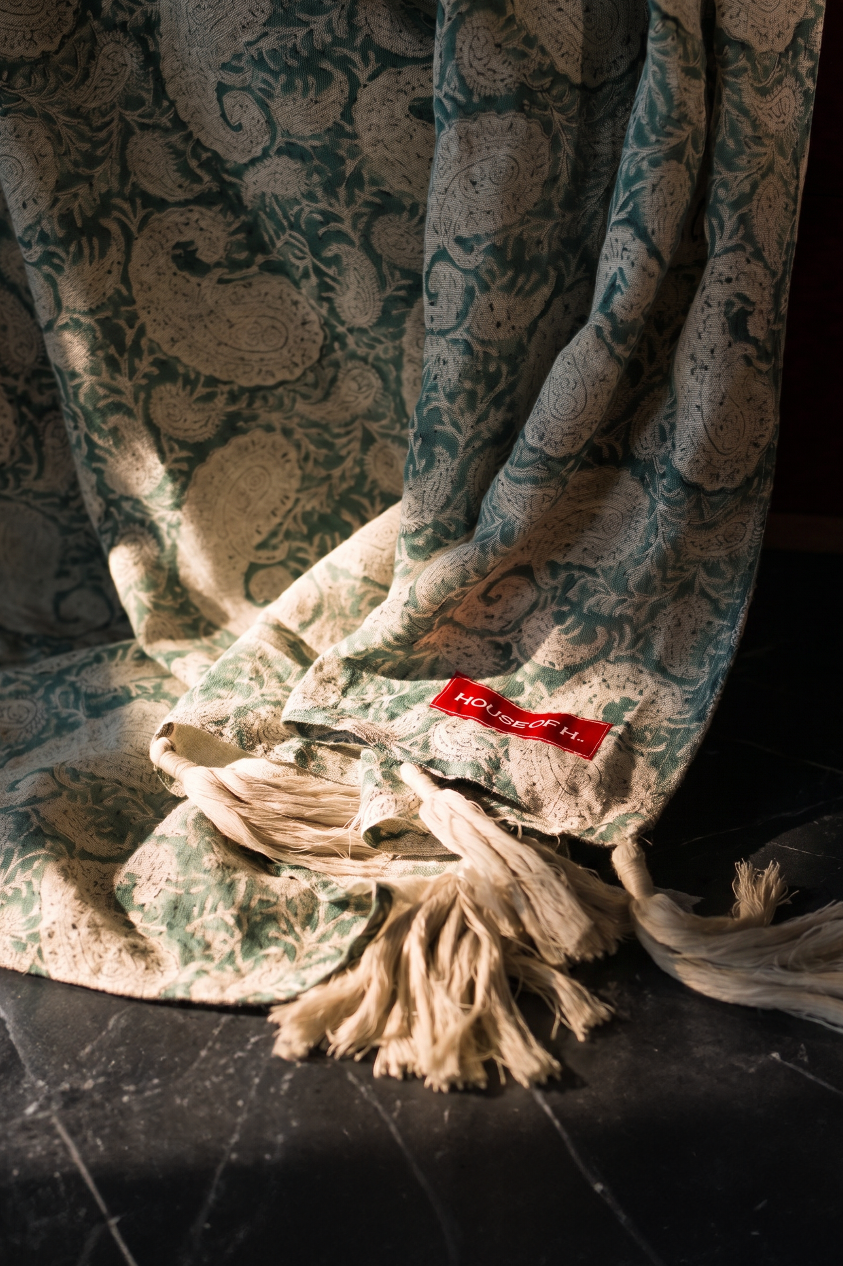 Teal hand block print European flax linen throw draped over a chair.