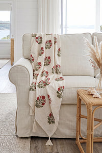 Pink floral hand block print linen throw styled over a chair in a living room.