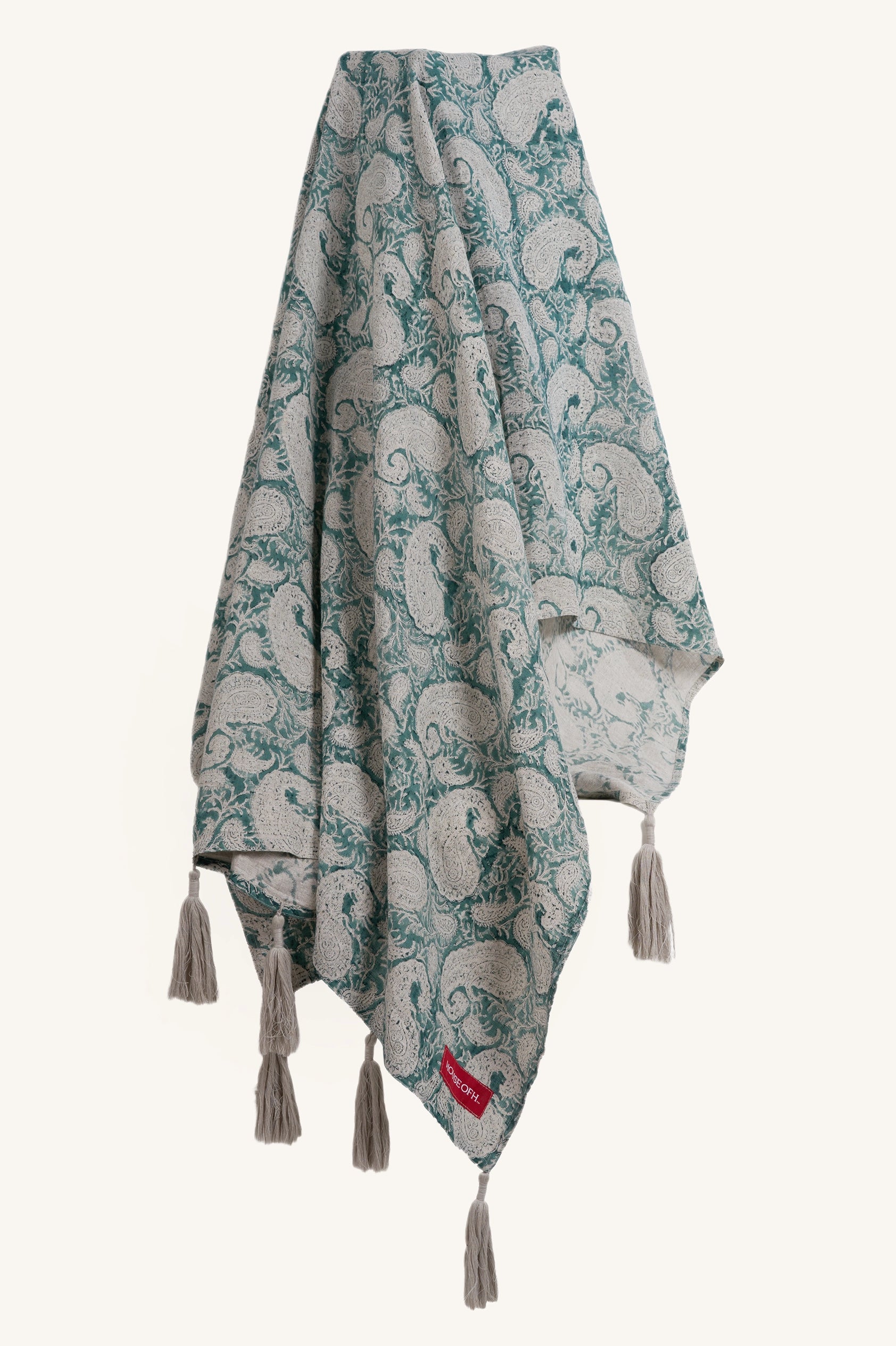 Teal hand block print European flax linen throw displayed hanging to show the full pattern and tassels.