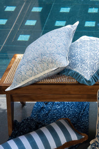 Blue hand block print European flax linen cushion styled outdoors with matching cushions.
