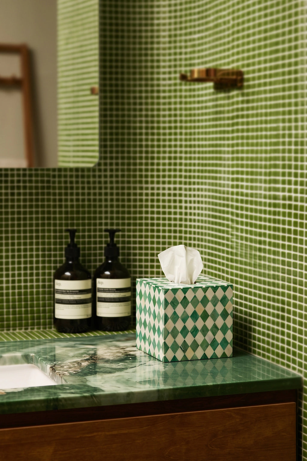 Green and white bone inlay tissue box styled on a bathroom vanity with soap dispensers.