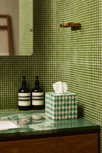 Green and white bone inlay tissue box styled on a bathroom vanity with soap dispensers.