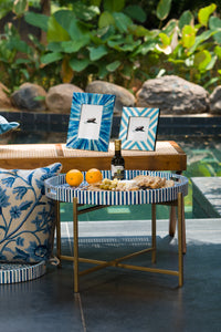 Blue and white chevron bone inlay photo frames styled outdoors on a side table.