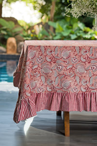 Pink floral hand block print cotton tablecloth styled on an outdoor dining table.
