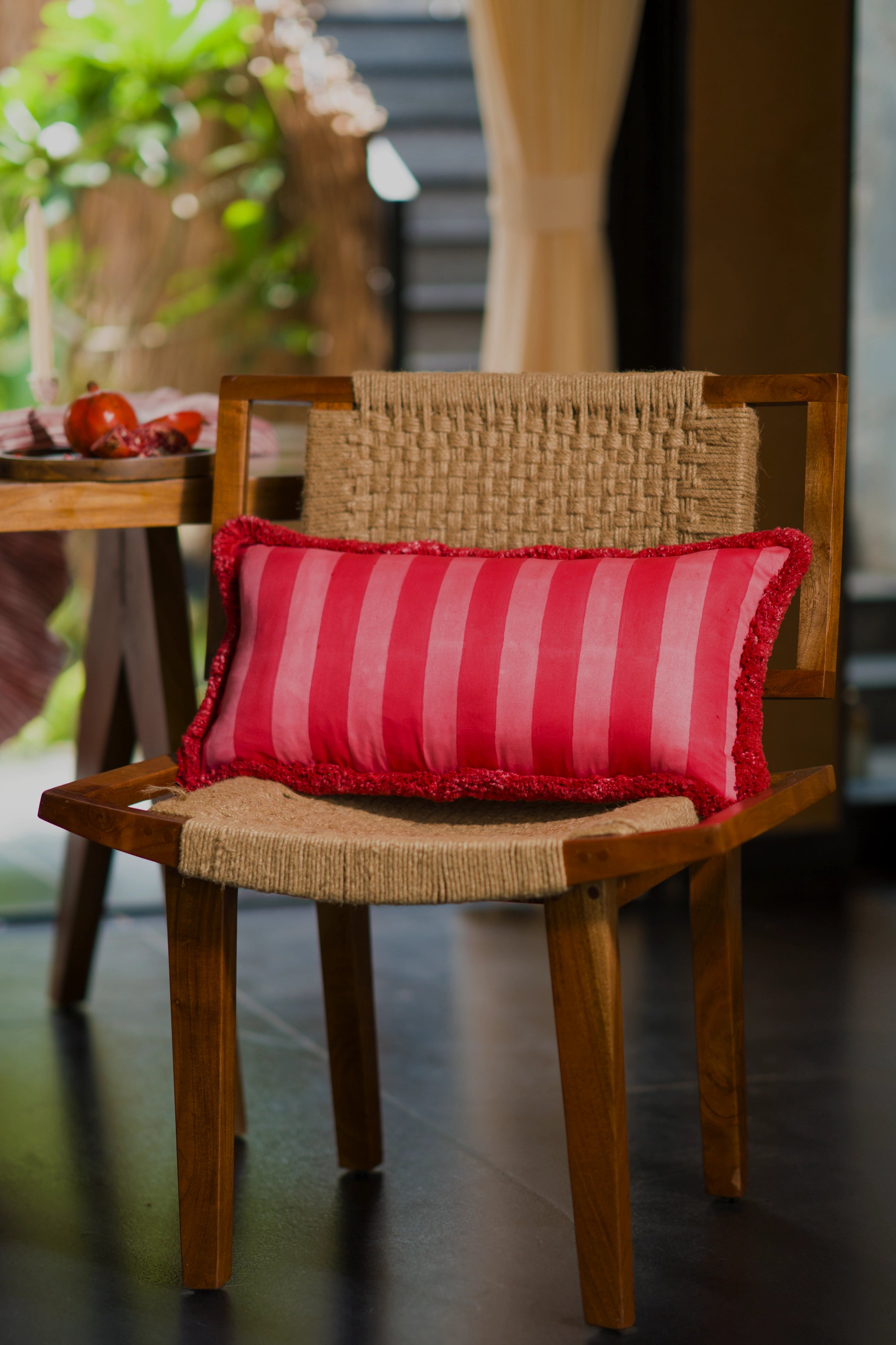 Red striped 1000 thread count cotton lumbar cushion styled on a timber chair.