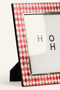 Close up of the red and ivory harlequin bone inlay pattern on the photo frame.