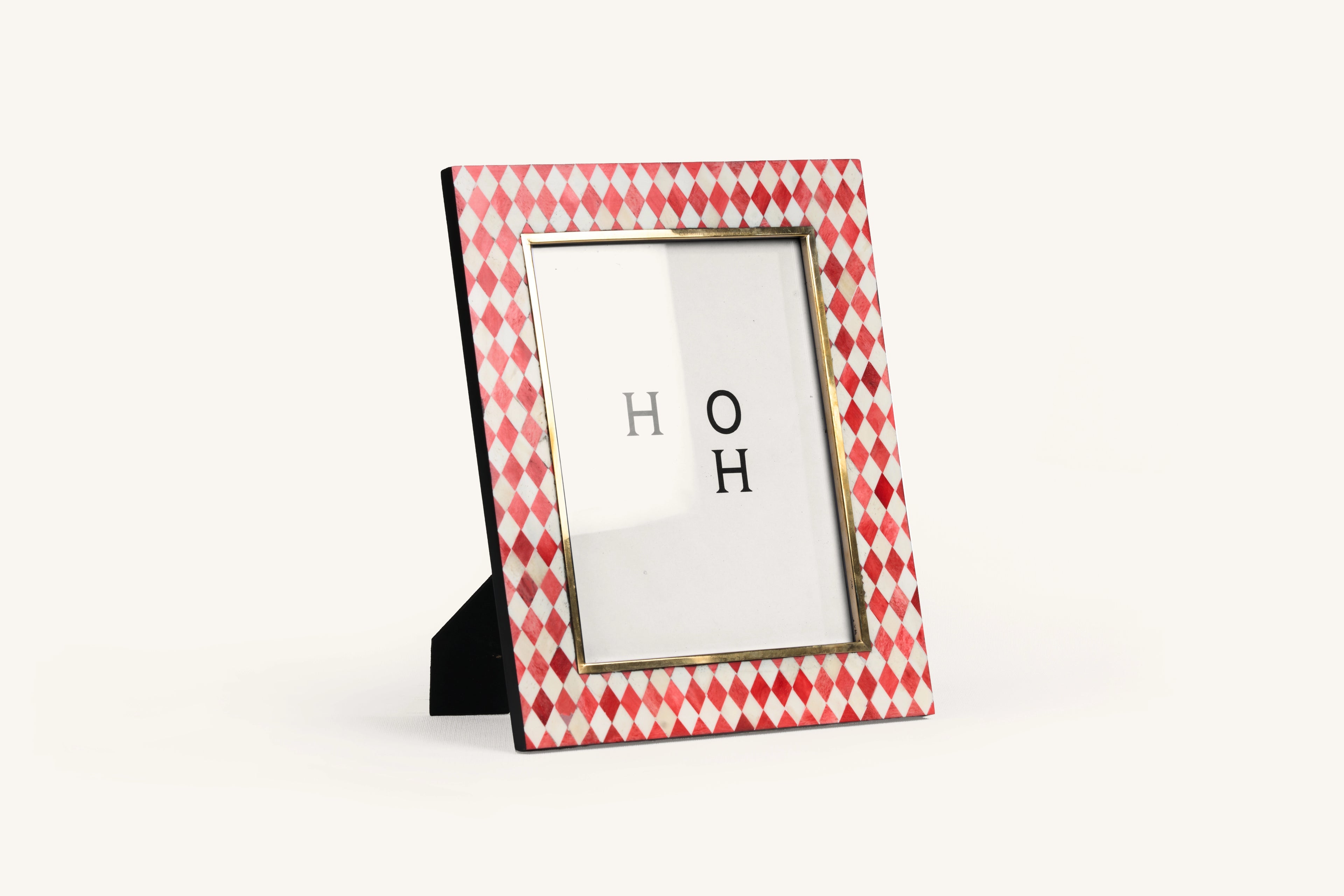 Rectangular red and ivory harlequin bone inlay photo frame with black edge.