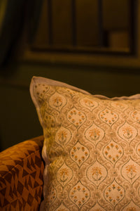 Taupe hand block print European flax linen cushion styled on a woven chair.