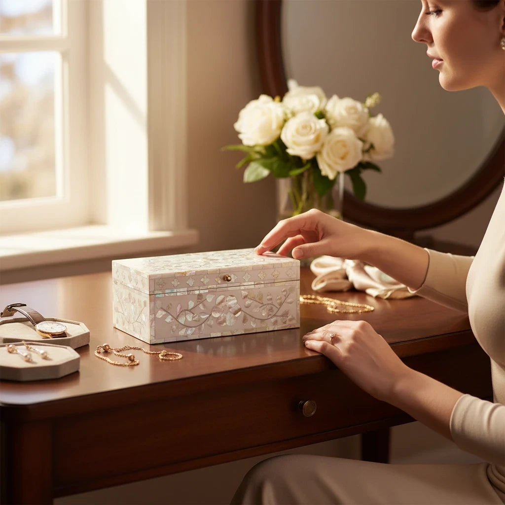 House of H Clover Box with mother of pearl floral inlay and brass knob on a wooden vanity table with a woman's hand.